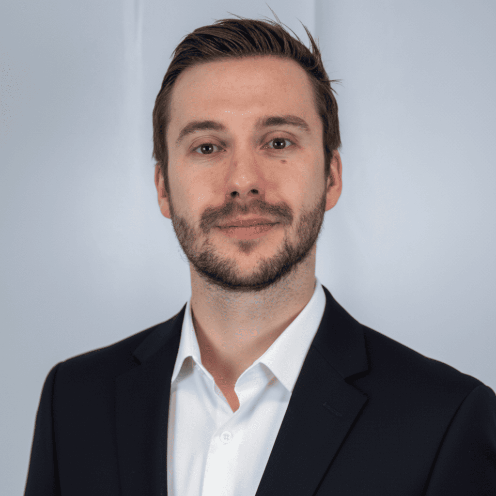 Portrait professionnel d’un formateur en finance de marché basé à Londres, en costume avec fond neutre